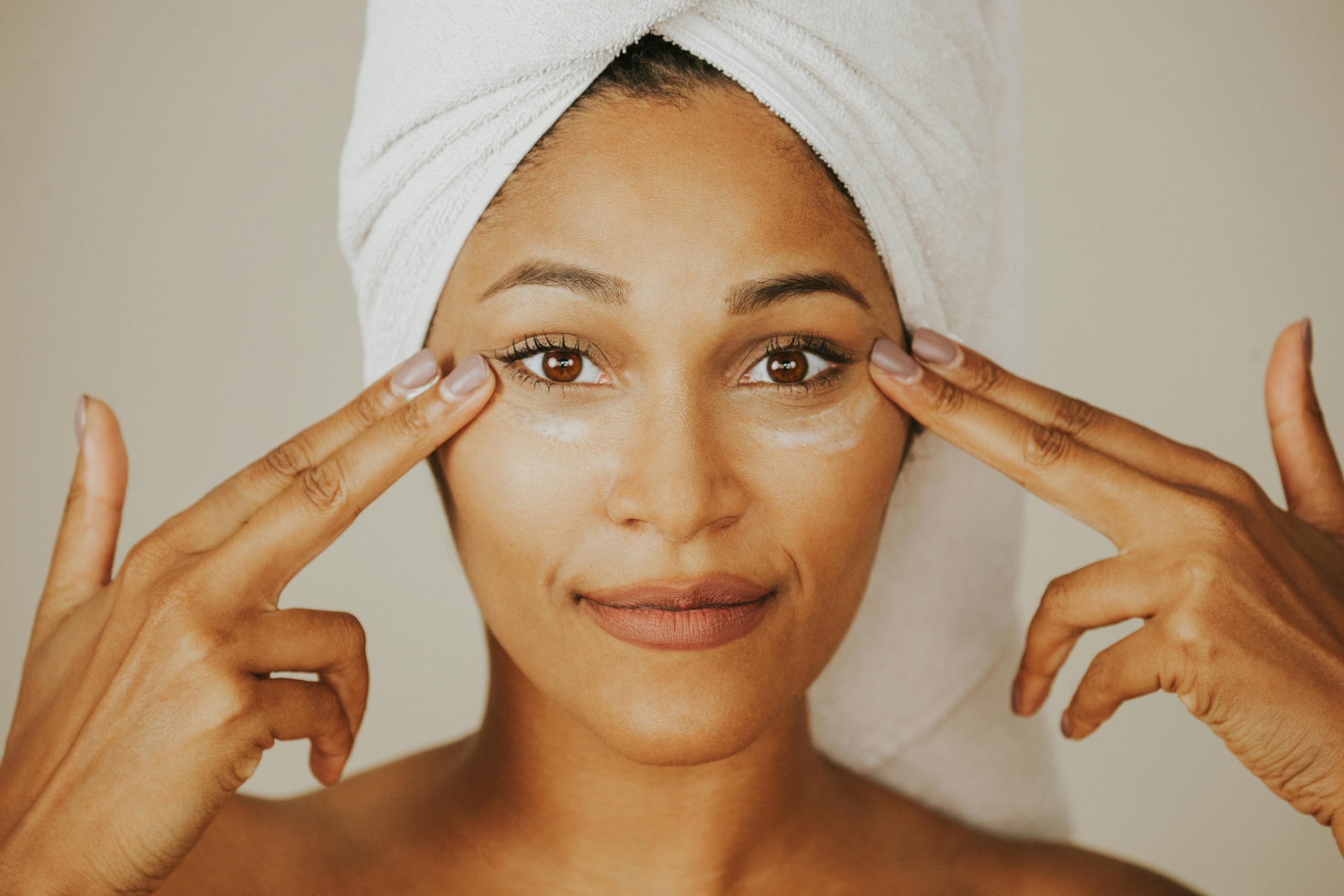 Woman holding facial oil representing skin longevity skincare philosophy